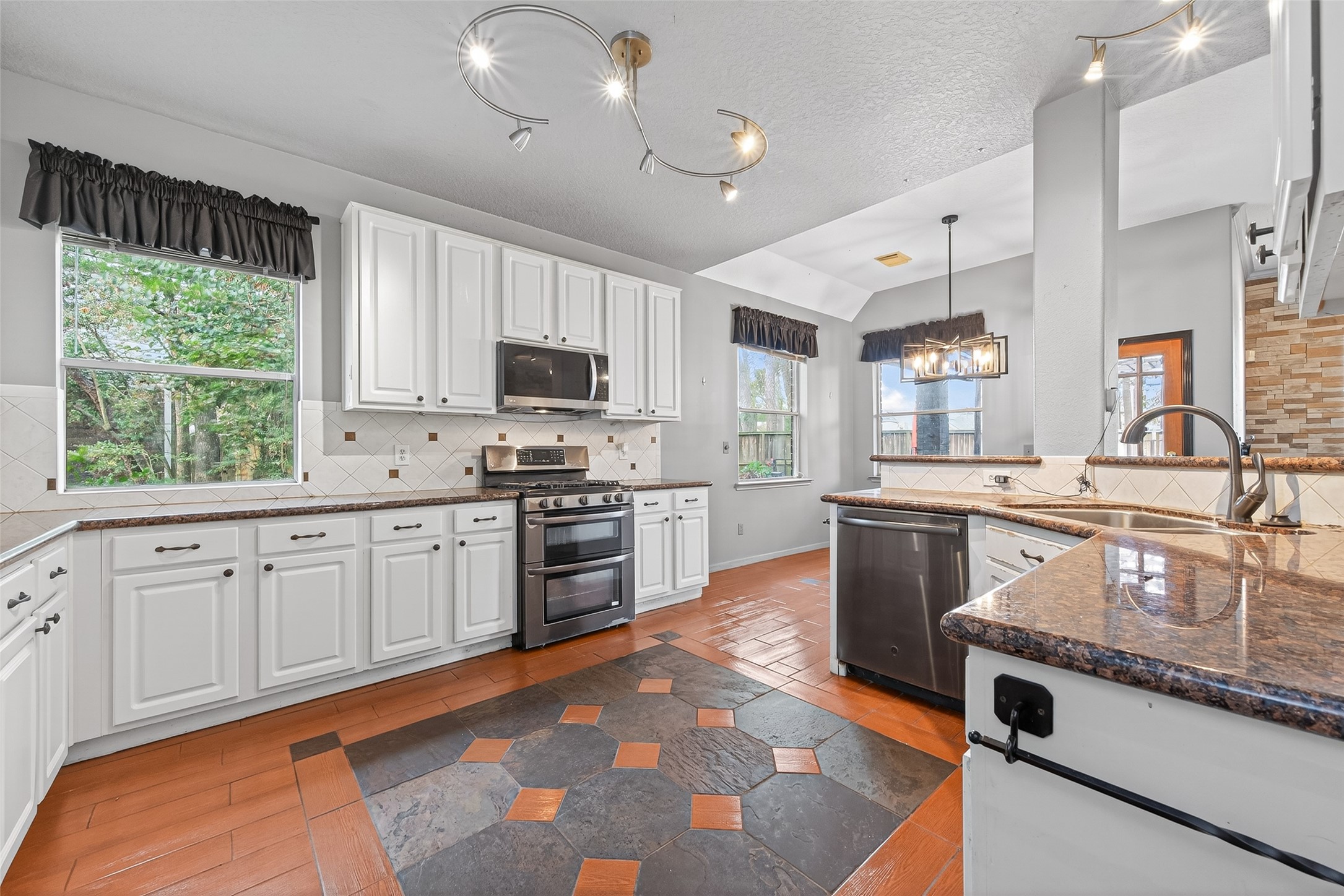 19331 Timber Tree Court Humble, TX 77346 - Photo 10 of 43 a kitchen with granite countertop a stove a sink and a refrigerator