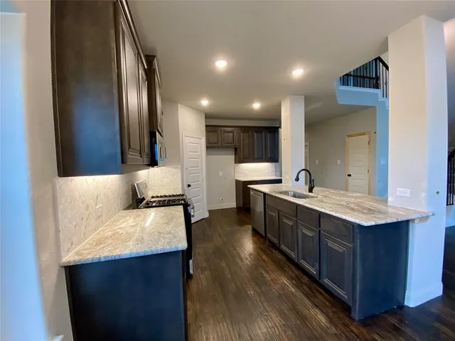 a large kitchen with stainless steel appliances sink a stove and a refrigerator