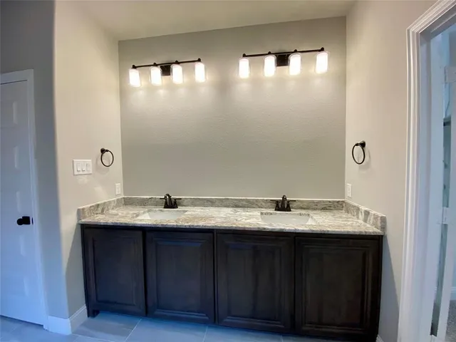 a bathroom with a granite countertop sink and a mirror