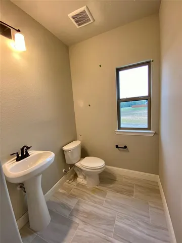 a white toilet sitting next to a bathroom sink