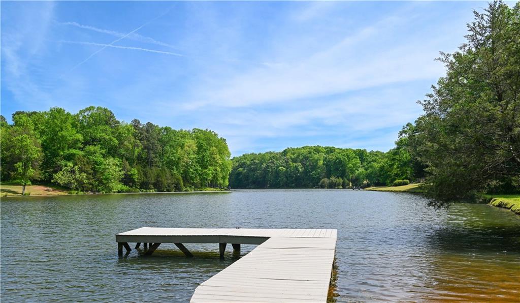 62 Cedar Trail Commerce, GA 30529 - Photo 97 of 115 a view of a lake with lawn chairs and large trees