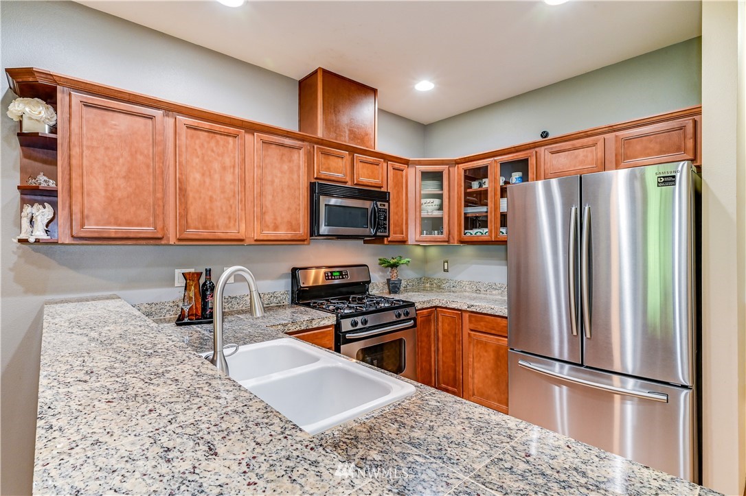 21334 11th Drive Southeast Bothell, WA 98021 - Photo 11 of 29 a kitchen with stainless steel appliances granite countertop a refrigerator sink and microwave