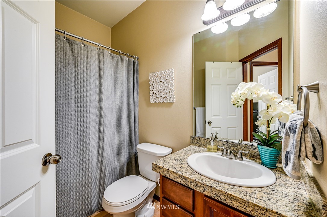 21334 11th Drive Southeast Bothell, WA 98021 - Photo 13 of 29 a bathroom with a granite countertop sink toilet a mirror a vanity and shower