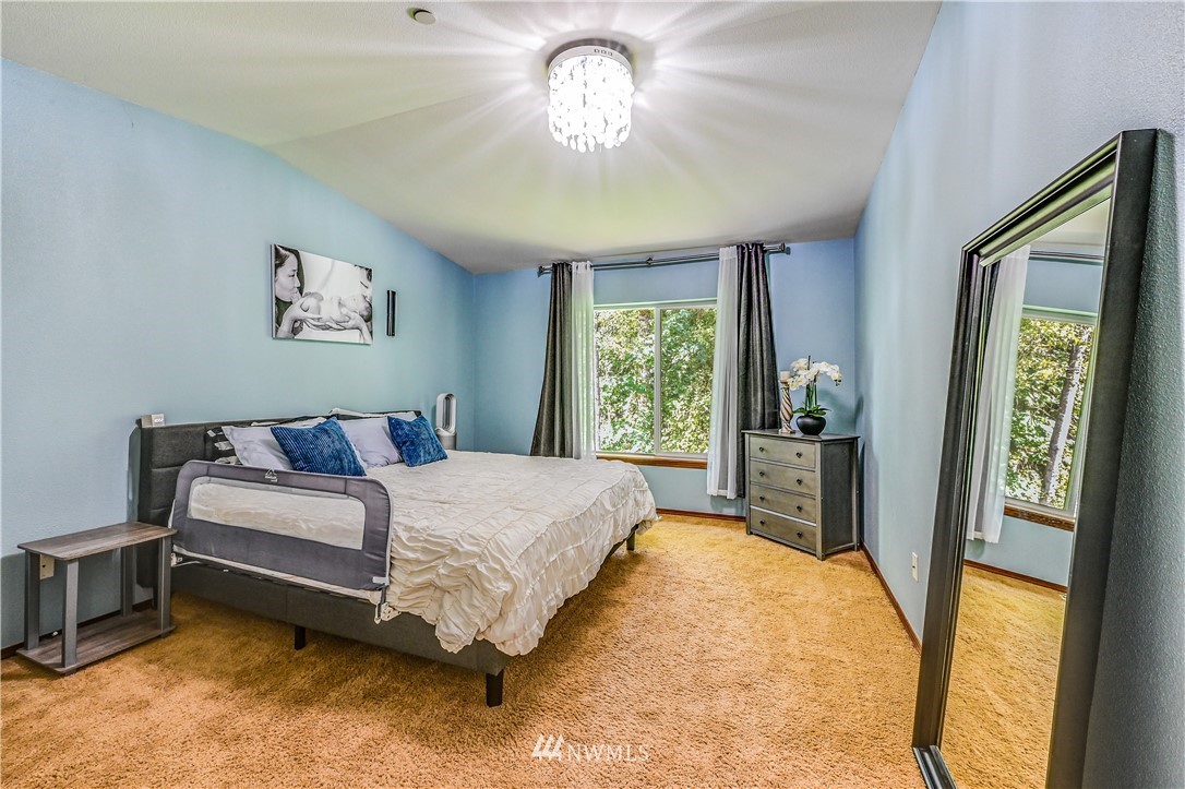 21334 11th Drive Southeast Bothell, WA 98021 - Photo 15 of 29 a spacious bedroom with a bed and a chandelier