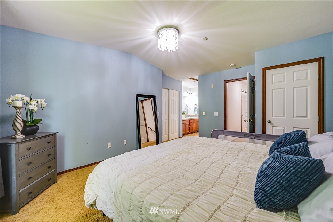 21334 11th Drive Southeast Bothell, WA 98021 - Photo 16 of 29 a bedroom with a bed and a chandelier