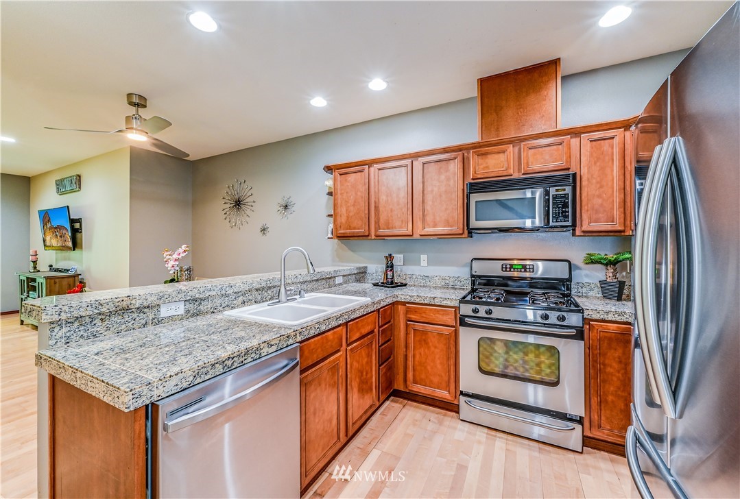 21334 11th Drive Southeast Bothell, WA 98021 - Photo 10 of 29 a kitchen with stainless steel appliances granite countertop a sink stove and refrigerator