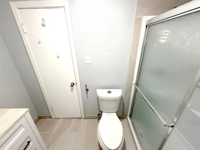 a white toilet sitting next to a shower