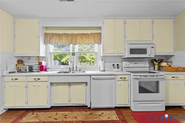 a kitchen with granite countertop white cabinets and white appliances