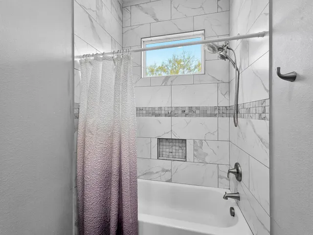 a bathroom with a bathtub and shower