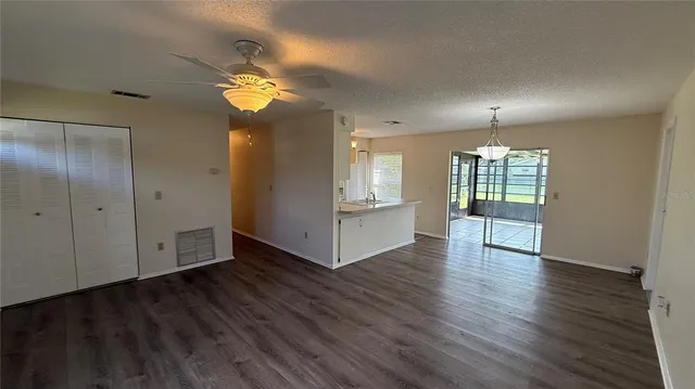 a view of an empty room with window and wooden floor