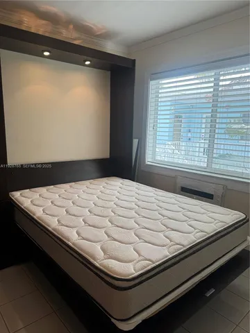 a bed sitting in a bedroom next to a window