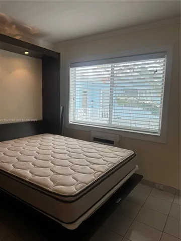 a bed sitting in a bedroom next to a window
