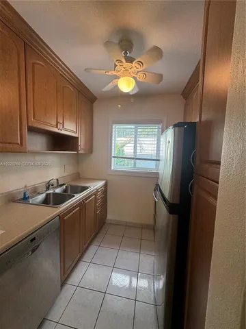 a kitchen with stainless steel appliances a sink a stove a microwave and cabinets