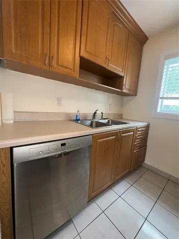 a kitchen with a refrigerator and a stove top oven
