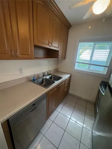 a kitchen with granite countertop white cabinets and stainless steel appliances