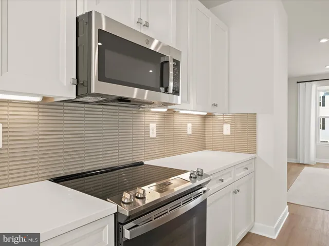 a large kitchen with a wooden floor and a refrigerator