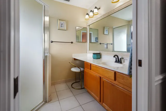 a spacious bathroom with a sink a mirror a toilet and a shower