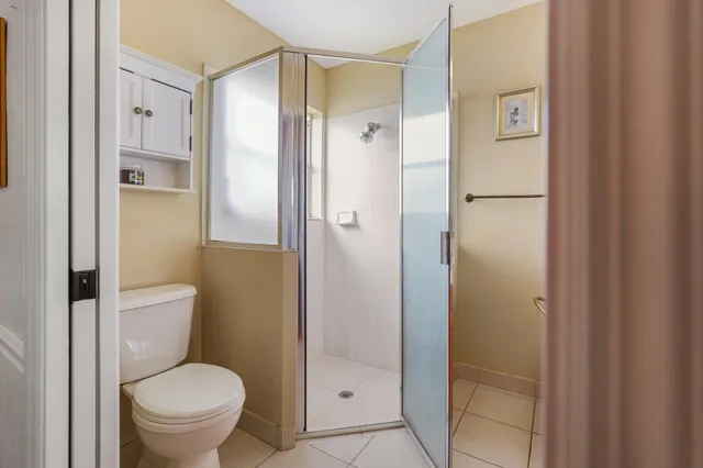 a bathroom with a granite countertop toilet a sink and a mirror