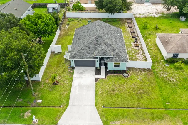 an aerial view of a house with swimming pool garden and patio
