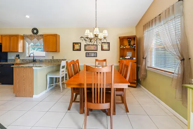 a dining room filled chandelier and kitchen view