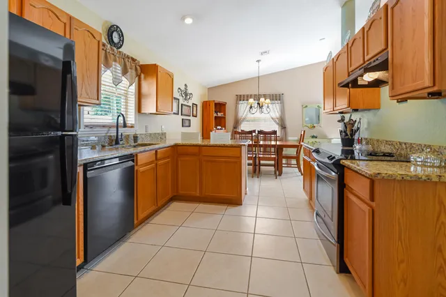 a kitchen with stainless steel appliances granite countertop a stove a sink and a refrigerator