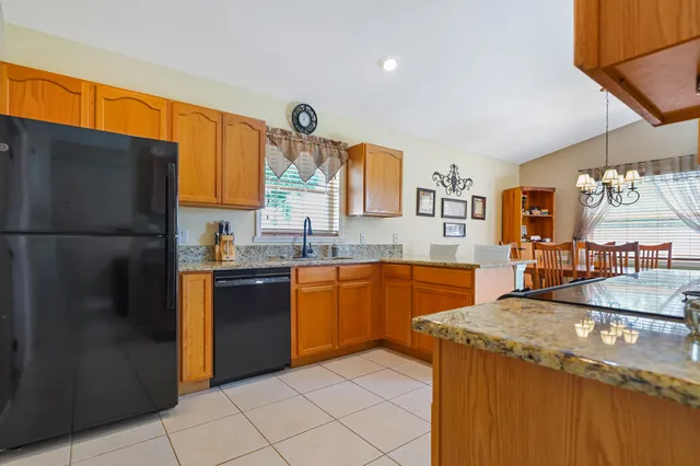 a kitchen with stainless steel appliances granite countertop a sink and a refrigerator