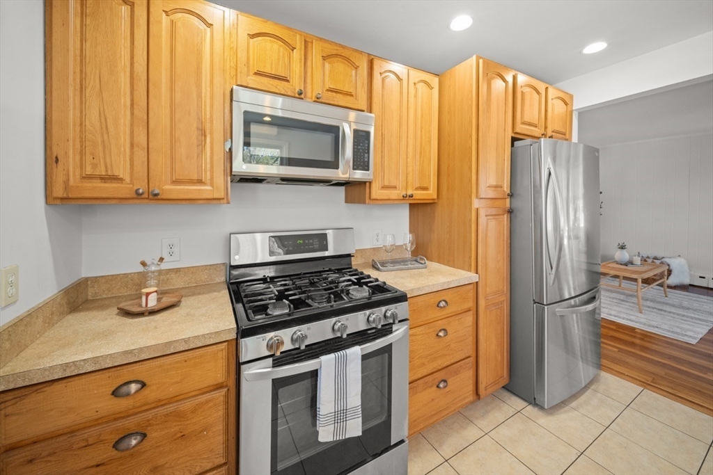 1180 Main Street, Unit 1 Waltham, MA 02451 - Photo 11 of 30 a kitchen with stainless steel appliances granite countertop a stove a refrigerator and a microwave