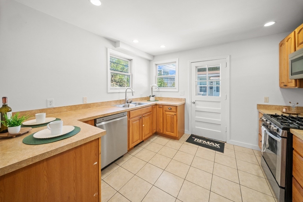 1180 Main Street, Unit 1 Waltham, MA 02451 - Photo 13 of 30 a kitchen with a sink stove and cabinets