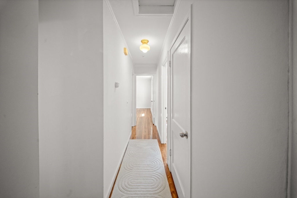 1180 Main Street, Unit 1 Waltham, MA 02451 - Photo 16 of 30 a view of a hallway with wooden floor and a lamp