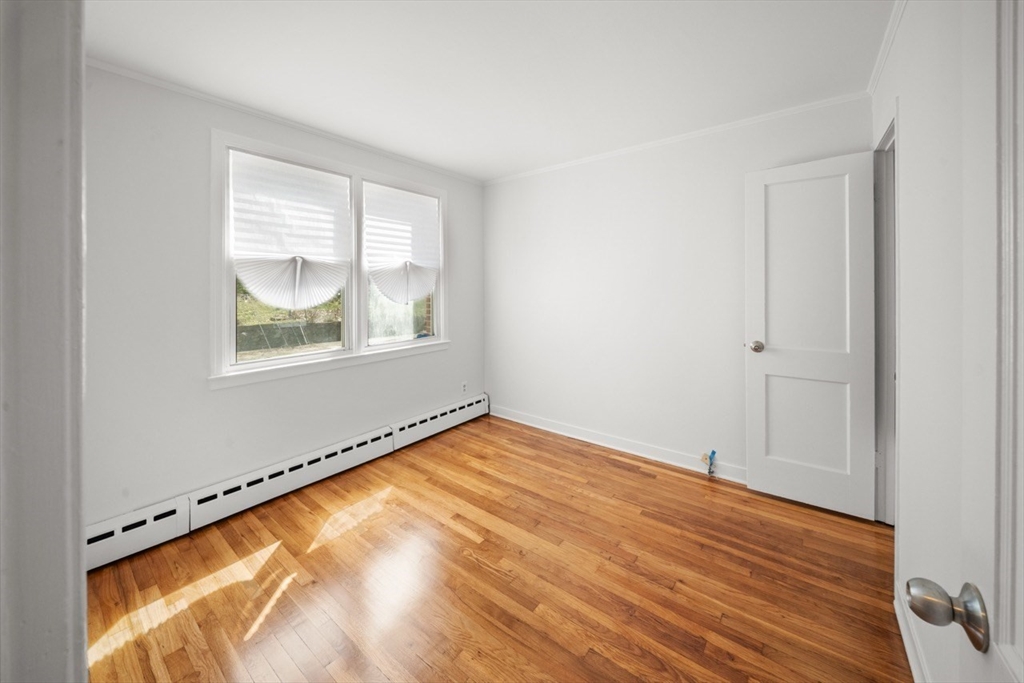 1180 Main Street, Unit 1 Waltham, MA 02451 - Photo 21 of 30 a view of an empty room with wooden floor and a window