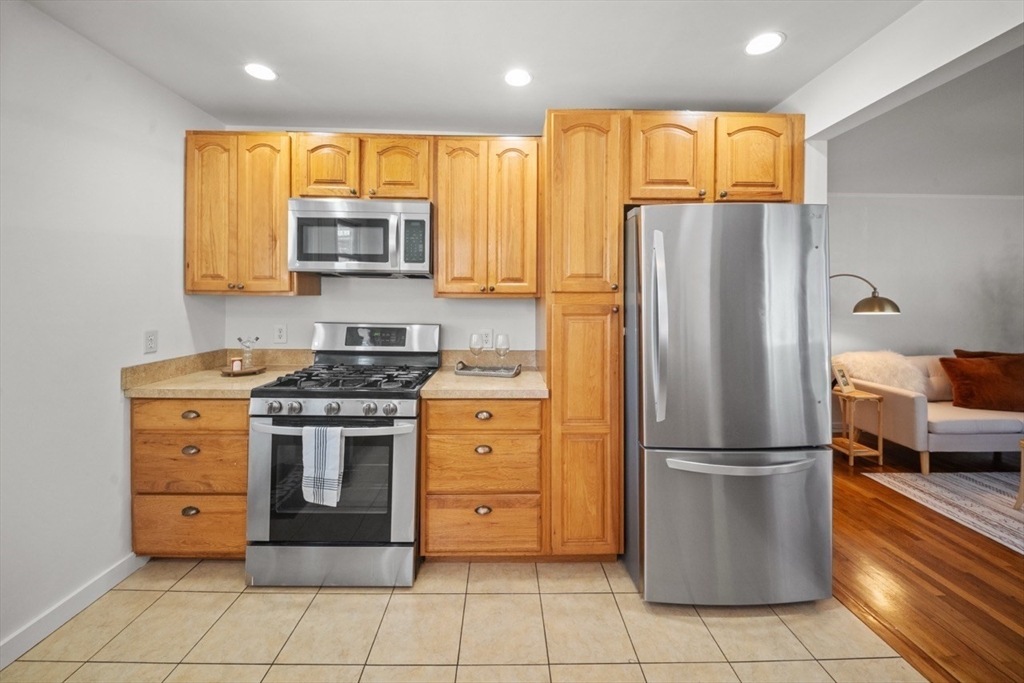 1180 Main Street, Unit 1 Waltham, MA 02451 - Photo 10 of 30 a kitchen with stainless steel appliances granite countertop a refrigerator and a stove
