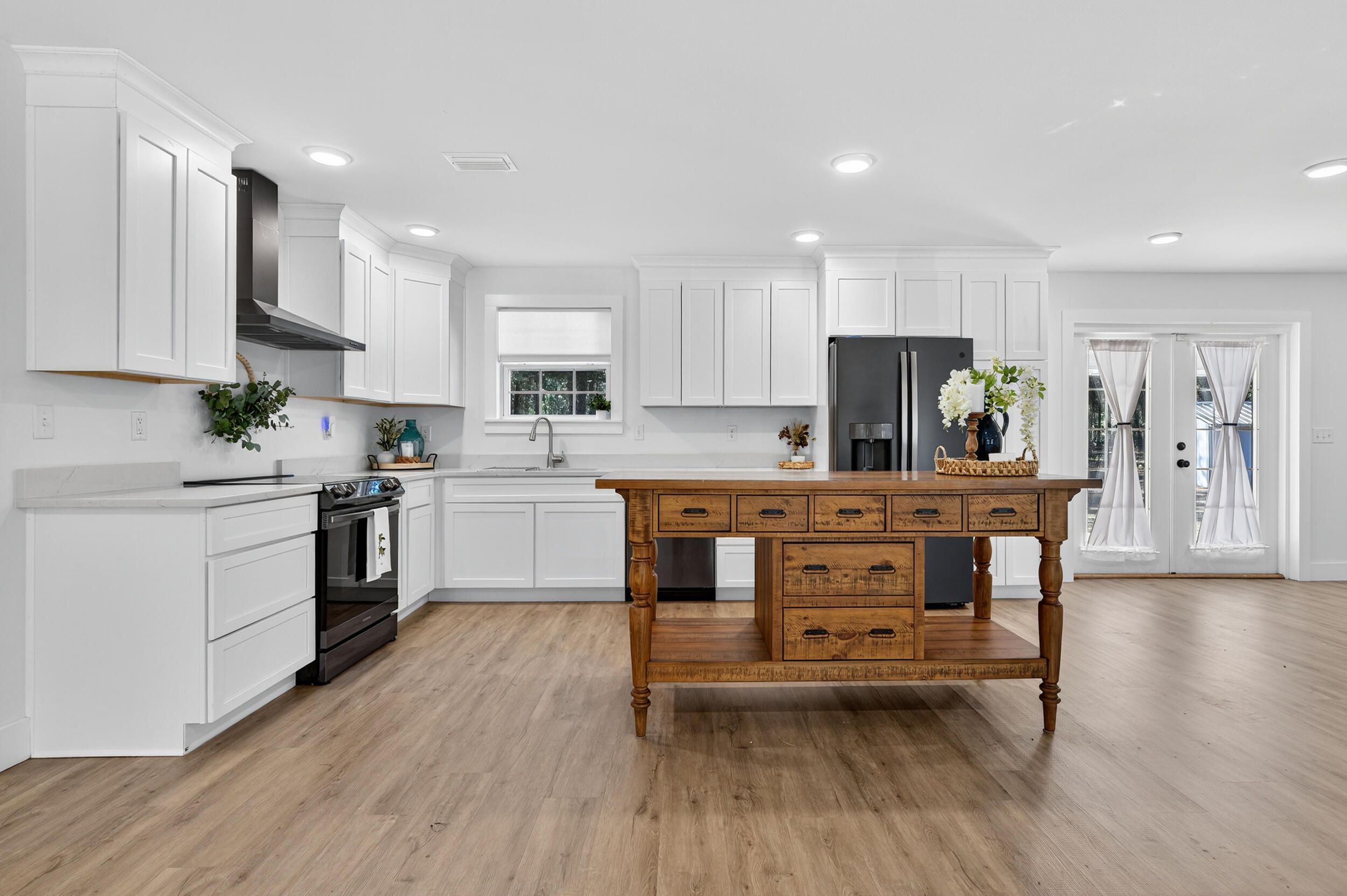 4734 Haybarn Road Holt, FL 32564 - Photo 11 of 54 a kitchen with a table chairs refrigerator and microwave