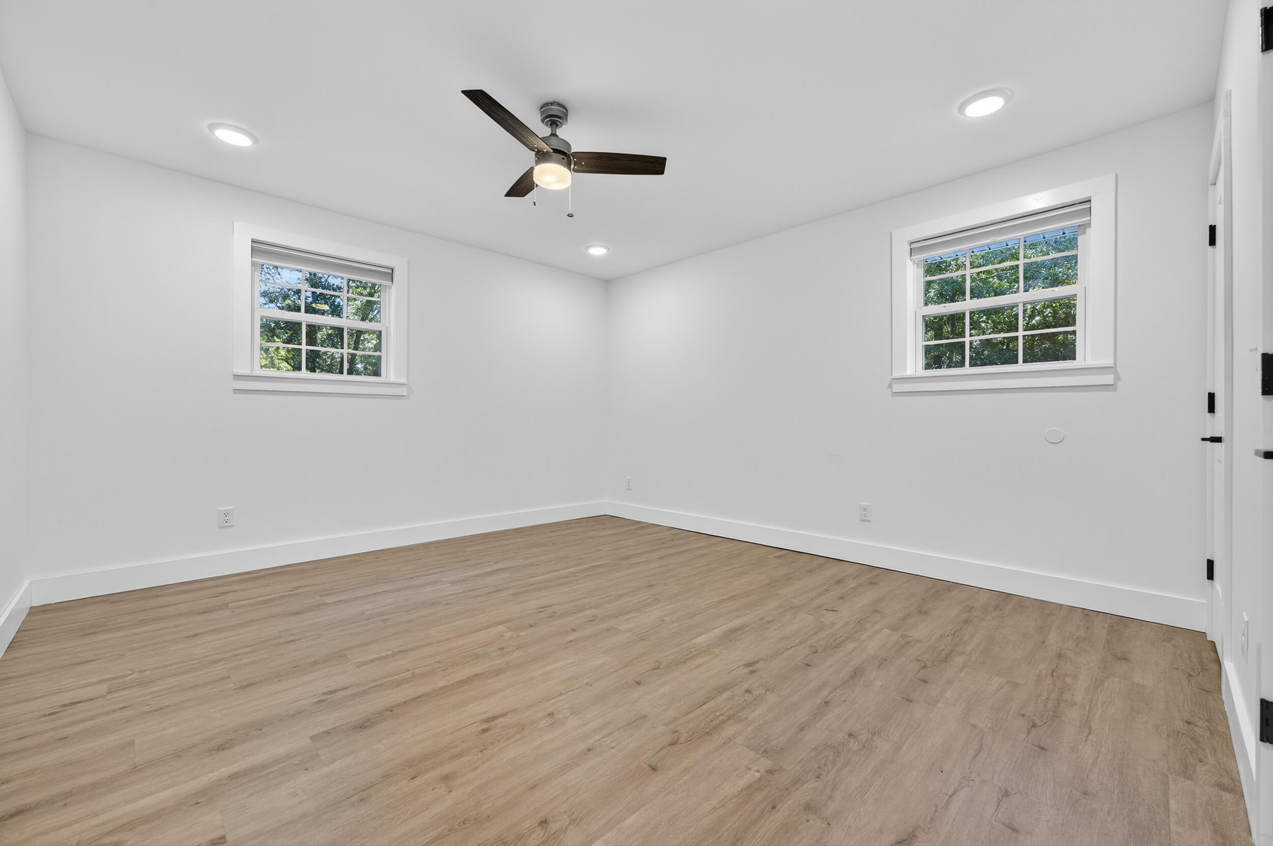 4734 Haybarn Road Holt, FL 32564 - Photo 24 of 54 an empty room with wooden floor ceiling fan and windows