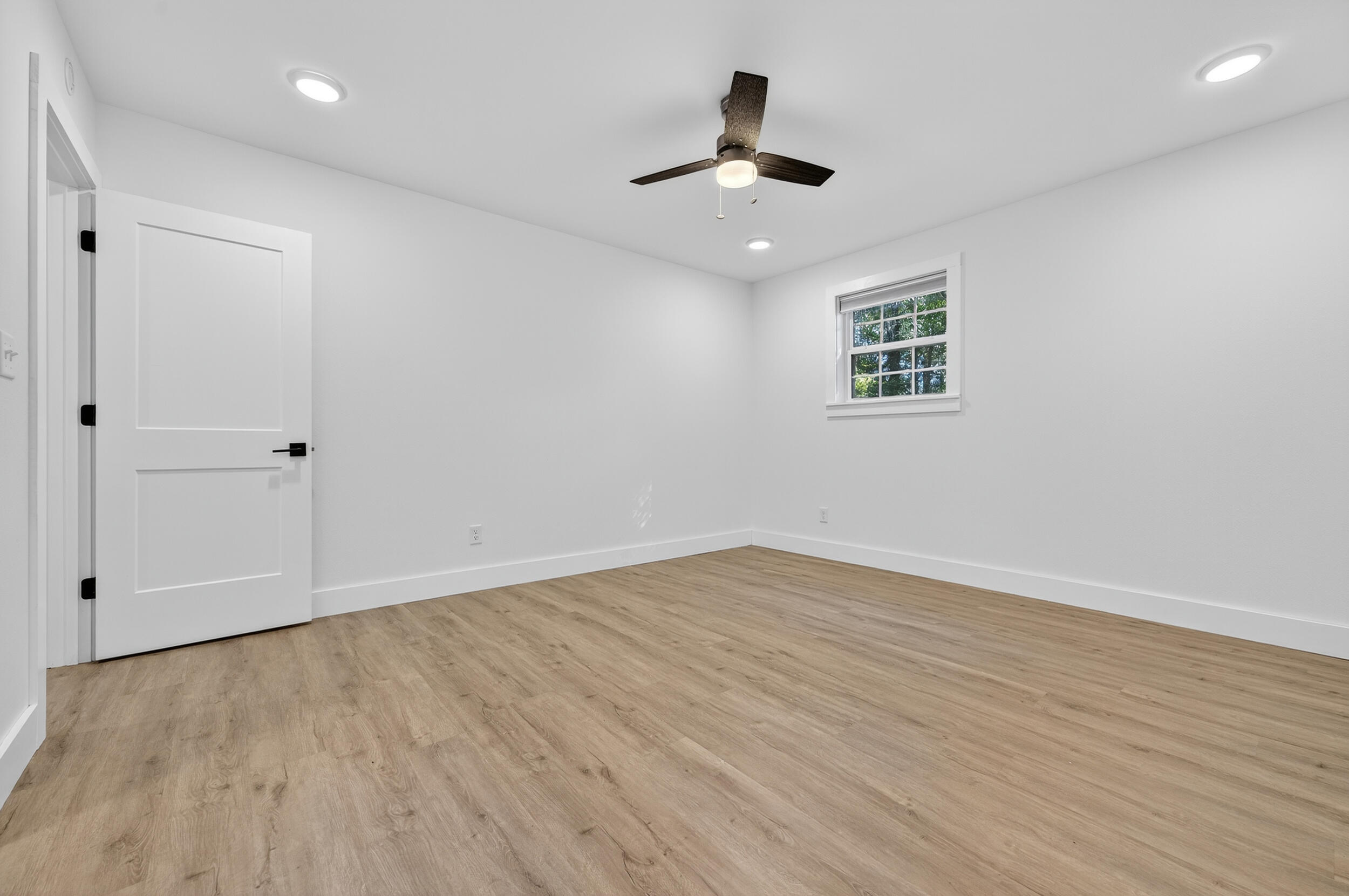 4734 Haybarn Road Holt, FL 32564 - Photo 28 of 54 a view of an empty room with wooden floor and a ceiling fan