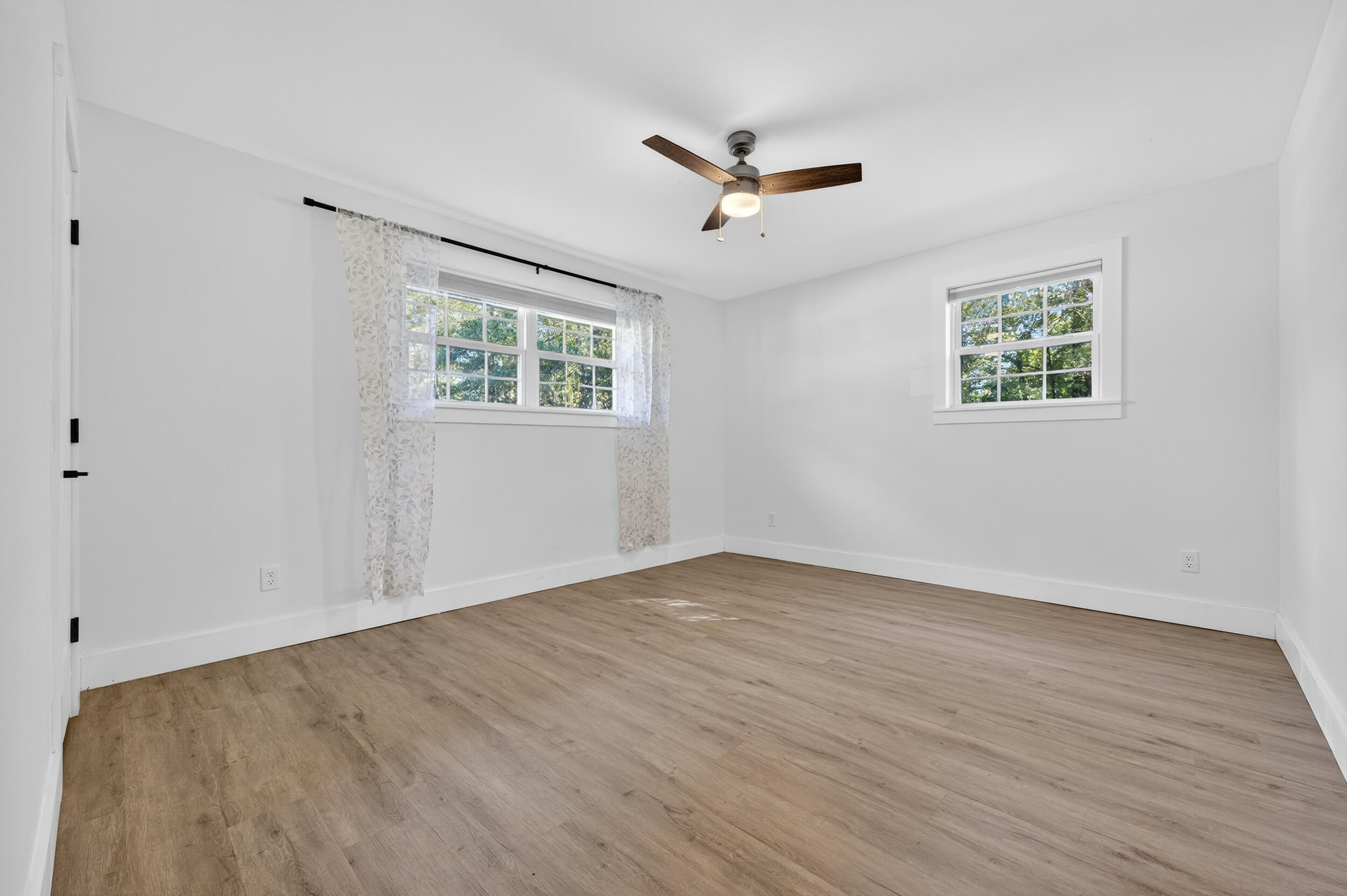 4734 Haybarn Road Holt, FL 32564 - Photo 31 of 56 an empty room with wooden floor ceiling fan and windows