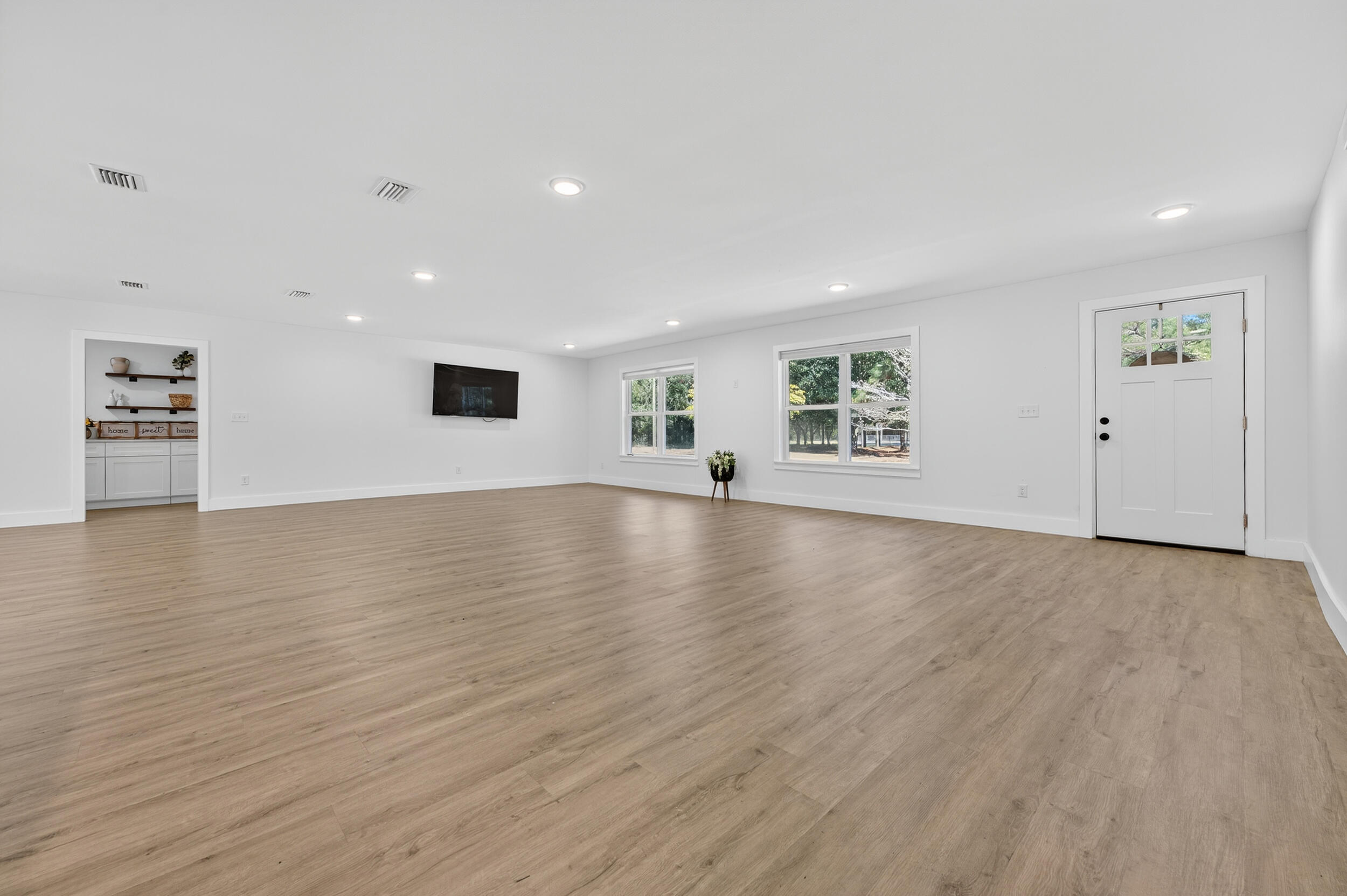 4734 Haybarn Road Holt, FL 32564 - Photo 5 of 54 an empty room with wooden floor and windows