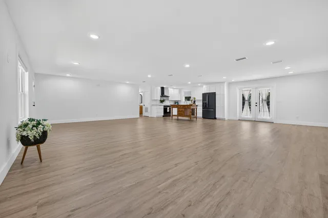 a view of a living room a kitchen with furniture and wooden floor