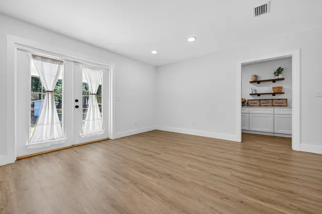a view of empty room with wooden floor
