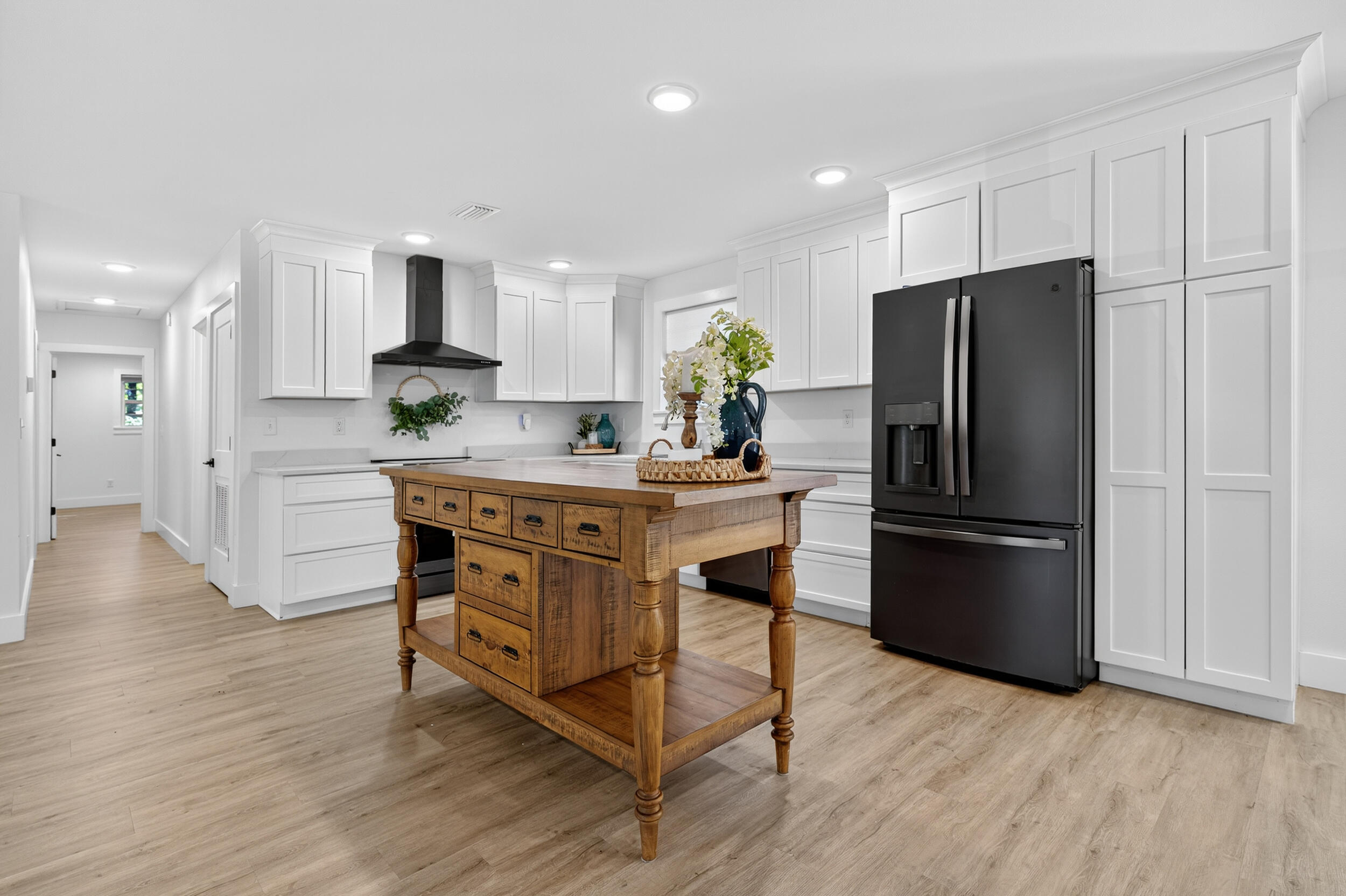 4734 Haybarn Road Holt, FL 32564 - Photo 10 of 54 a kitchen with stainless steel appliances a refrigerator a sink dishwasher a stove a dining table and chairs with wooden floor