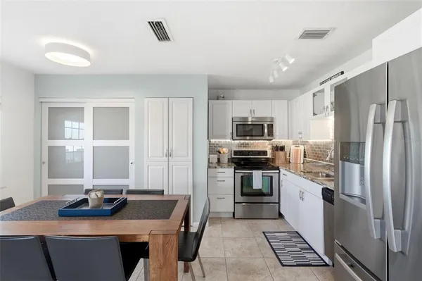 a kitchen with stainless steel appliances granite countertop a refrigerator and a stove top oven