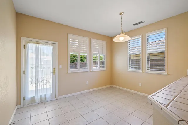 an empty room with a window and a ceiling fan