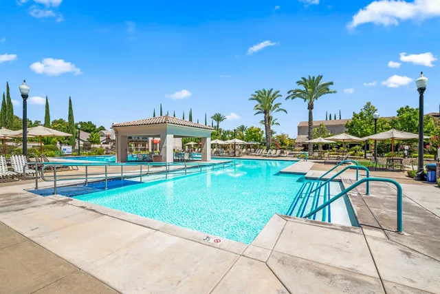 a patio with a table and chairs under an umbrella
