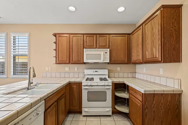 a kitchen with stainless steel appliances granite countertop a sink stove and cabinets