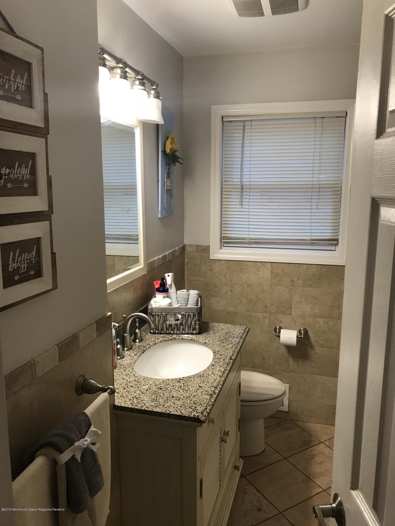 14 Chain Boulevard Bayville, NJ 08721 - Photo 15 of 17 a bathroom with a granite countertop sink a toilet and a mirror