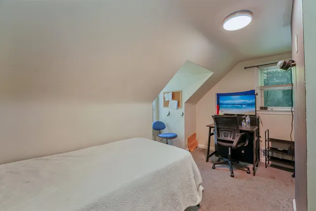 a bedroom with a bed a desk and chair