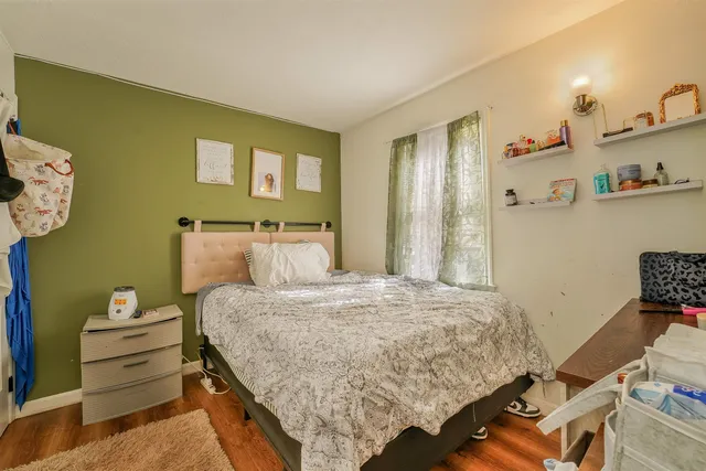 a bedroom with a bed and wooden floor