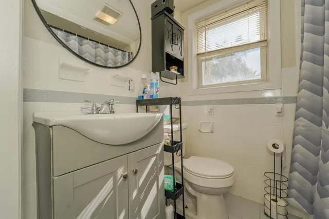 a bathroom with a sink a toilet and a mirror