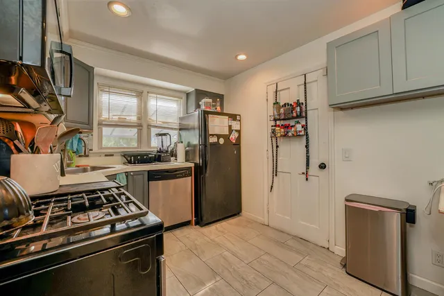a kitchen with stainless steel appliances granite countertop a refrigerator stove and sink