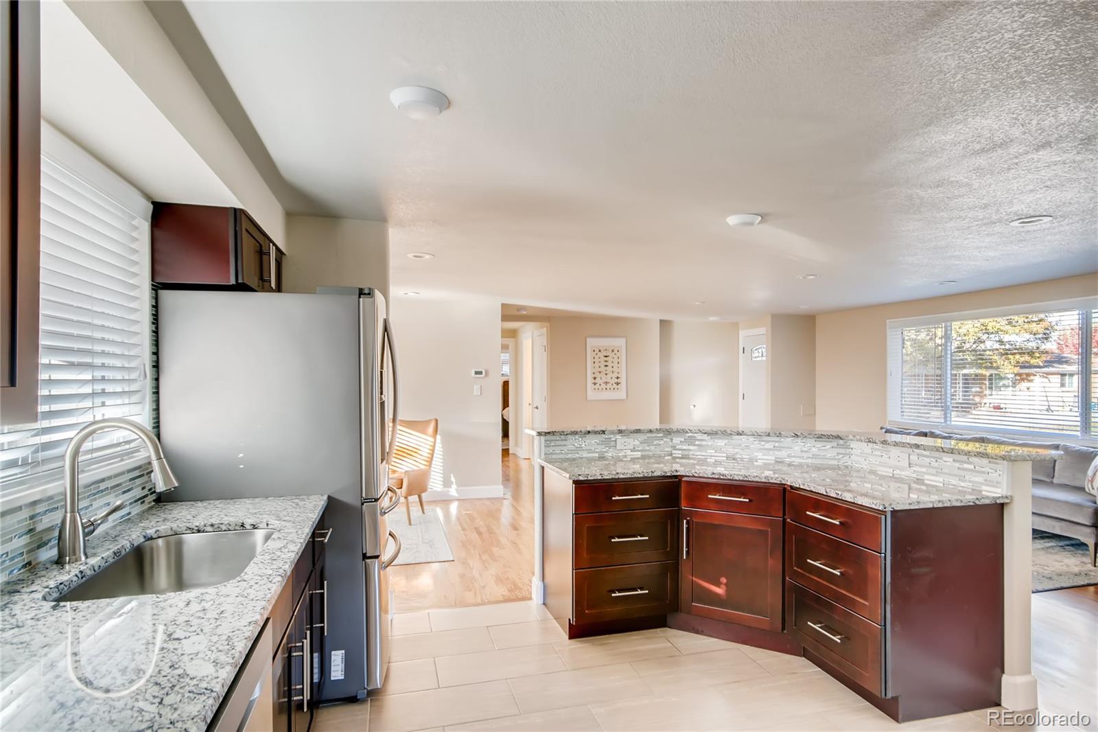5655 Estes Street Arvada, CO 80002 - Photo 15 of 40 a kitchen with granite countertop a sink and a stove