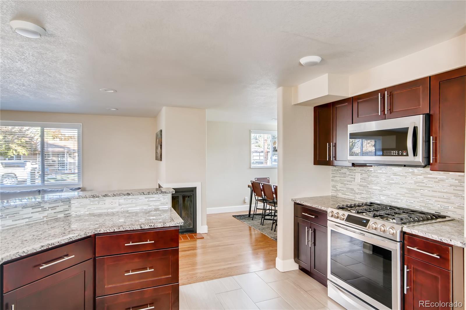 5655 Estes Street Arvada, CO 80002 - Photo 16 of 40 a kitchen with granite countertop a stove and a sink